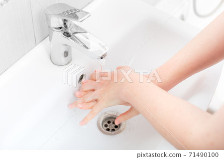 washing femle hands in a ceramic washbasin with a chrome tap, the bacteria of the covid-19 virus are washed off, close up faceless. washing femle hands in a ceramic washbasin with a chrome tap, the bacteria of the covid-19 virus are washed off, close up faceless. 71490100