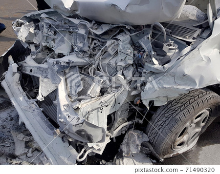engine compartment damaged by accident and covered with a layer of white foam after extinguishing a car in a disaster, close-up of damaged parts after a front collision. 71490320