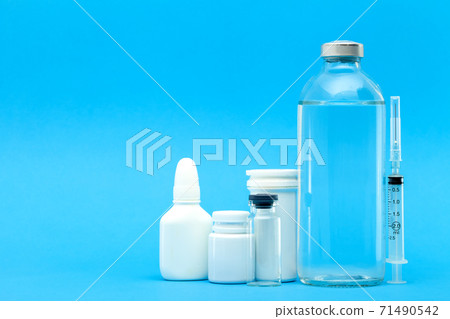 pharmaceuticals for the treatment of diseases unlabeled plastic and glass bottles with pills and vaccines on a blue background with copy space. 71490542