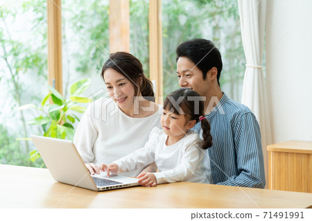 一個女孩和一台筆記本電腦一起學習,媽媽和爸爸看著它 一個女孩和一台筆記本電腦一起學習,媽媽和爸爸看著它 71491991