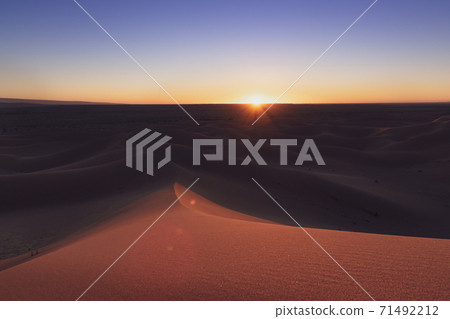 Huge desert dunes of Erg Chigaga, at the gates of the Sahara, at sunset. Morocco. Concept of travel and adventure. Huge desert dunes of Erg Chigaga, at the gates of the Sahara, at sunset. Morocco. Concept of travel and adventure. 71492212