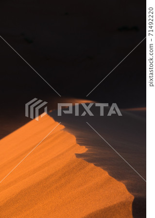 Close-up of sand desert dunes of Erg Chigaga moved by the wind. The gates of the Sahara, at sunrise. Morocco. Concept of travel and adventure Close-up of sand desert dunes of Erg Chigaga moved by the wind. The gates of the Sahara, at sunrise. Morocco. Concept of travel and adventure 71492220