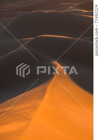 Huge desert dunes of Erg Chigaga, at the gates of the Sahara, al amanecer. Morocco. Concept of travel and adventure. Huge desert dunes of Erg Chigaga, at the gates of the Sahara, al amanecer. Morocco. Concept of travel and adventure. 71492224