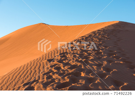 Wide angle shoot of footpath in desert dunes of Erg Chigaga.The gates of the Sahara, at sunrise. Morocco. Concept of travel and adventure Wide angle shoot of footpath in desert dunes of Erg Chigaga.The gates of the Sahara, at sunrise. Morocco. Concept of travel and adventure 71492226