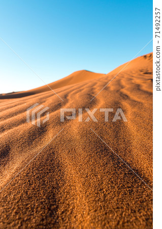 Daytime close-up desert dunes of Erg Chigaga, at the gates of the Sahara. Morocco. Concept of travel and adventure. Daytime close-up desert dunes of Erg Chigaga, at the gates of the Sahara. Morocco. Concept of travel and adventure. 71492257