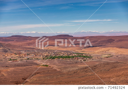 Daytime wide angle shoot of a town and the Atlas Mountains in the background, Morocco. Daytime wide angle shoot of a town and the Atlas Mountains in the background, Morocco. 71492324