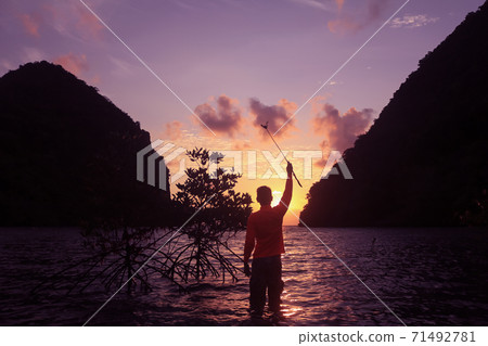 Men playing with sea water in the morning by the beach at sunrise. Men playing with sea water in the morning by the beach at sunrise. 71492781