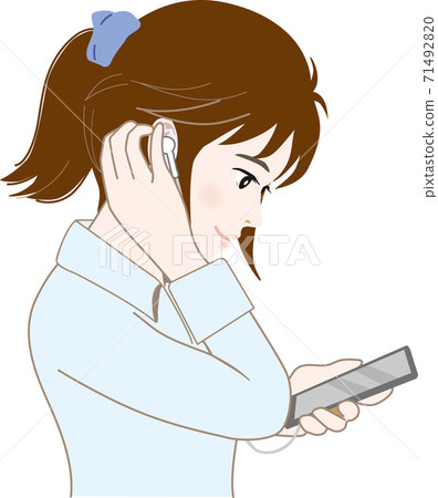 一個女人在她的手機上聽音樂 71492820