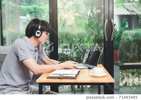 Businessman video call with clients on laptop in home office. Man wear headphone video calling or distance education e-leaning online course. 71493405