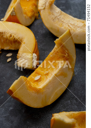 Pumpkin slices isolated on dark background, fall food. 71494152