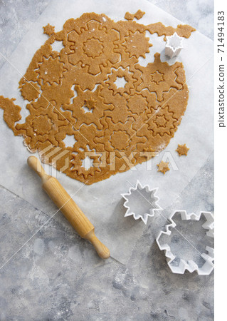 Christmas baking cookies snowflakes shape. Raw dough, cookie cutters, rolling pin. Abstract winter food background. 71494183