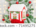 christmas gingerbread house on the hand with christmas tree bokeh 71495275