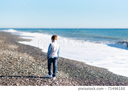 Young baby boy walking along shoreline of beach Young baby boy walking along shoreline of beach 71496188