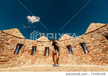 Woman tourist walks on the fortress of the city of Avila in Spain Woman tourist walks on the fortress of the city of Avila in Spain 71496189