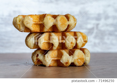 A delicious baked round Belgian waffle with one bite taken. A delicious baked round Belgian waffle with one bite taken. 71496250