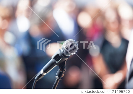 Microphone in focus against blurred audience Microphone in focus against blurred audience 71496760