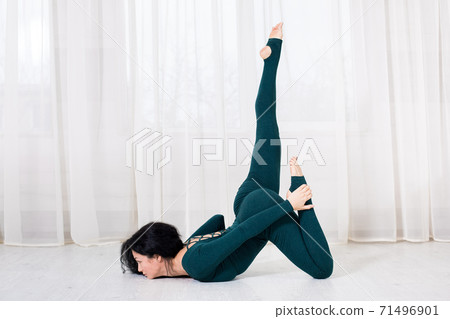 alone girl in sportswear doing yoga exercises on the floor in the light room during quarantine of covid 19 cotonavirus stay home safe world. 71496901