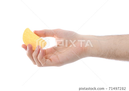Male hand holding potato chip Male hand holding potato chip 71497282