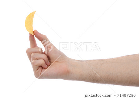Male hand holding potato chip 71497286