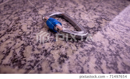 Screw gate carabiner used for rock climbing and mountain sports on a marble top 71497654