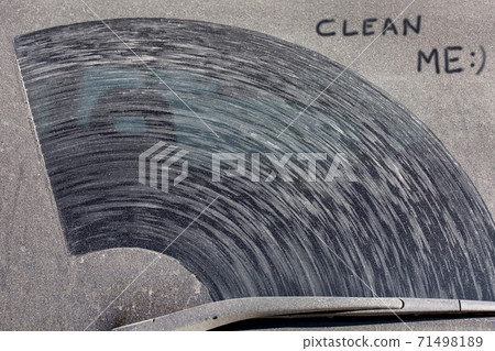 the inscription clean me on hatchback back window of a dirty car in a layer of dust and dry dirt, close up of a dirty vehicle rear view. 71498189