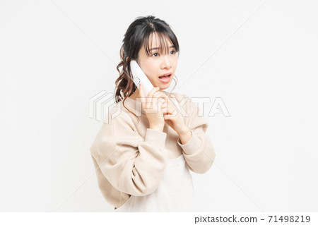 A young woman who is surprised and surprised while talking on the phone A young woman who is surprised and surprised while talking on the phone 71498219