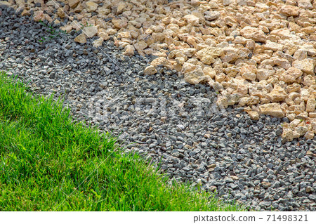 Landscaping yard with rows of stones scattered with green lawn, close up decor detail. Landscaping yard with rows of stones scattered with green lawn, close up decor detail. 71498321