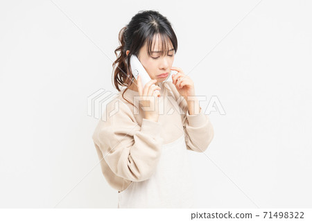 Young woman crying while talking on the phone Young woman crying while talking on the phone 71498322