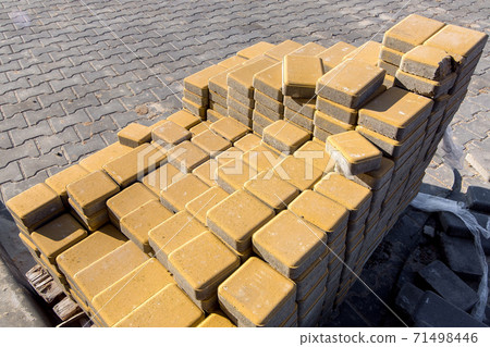 New yellow paving slabs folded in a pile one on top of another on a sunny day, close up. New yellow paving slabs folded in a pile one on top of another on a sunny day, close up. 71498446