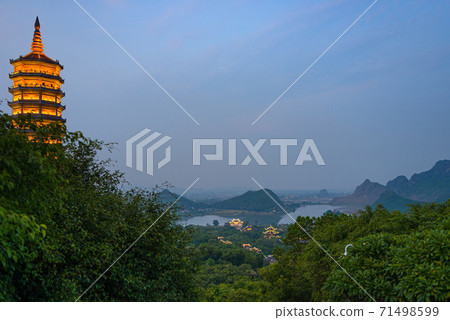 Bai Dinh Pagoda at twilight, Ninh Binh, the biggest buddhist temple complex in Vietnam, tourist religious travel destination. Scenic karst landscape. Bai Dinh Pagoda at twilight, Ninh Binh, the biggest buddhist temple complex in Vietnam, tourist religious travel destination. Scenic karst landscape. 71498599