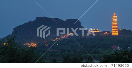 Bai Dinh Pagoda at twilight, Ninh Binh, the biggest buddhist temple complex in Vietnam, tourist religious travel destination. Scenic karst landscape. Bai Dinh Pagoda at twilight, Ninh Binh, the biggest buddhist temple complex in Vietnam, tourist religious travel destination. Scenic karst landscape. 71498600