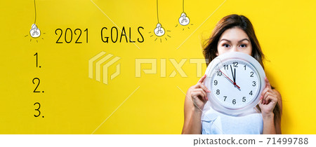 2021 goals with young woman holding a clock 2021 goals with young woman holding a clock 71499788