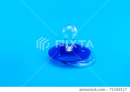 a round pacifier babies made of transparent soft latex, mock up plastic soother isolated on blue background with copy space. 71500517