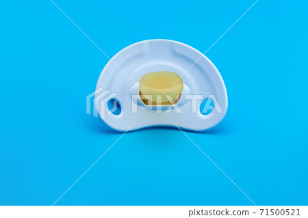 a blue pacifier made of soft silicone isolated on blue background front view with copy space. a blue pacifier made of soft silicone isolated on blue background front view with copy space. 71500521
