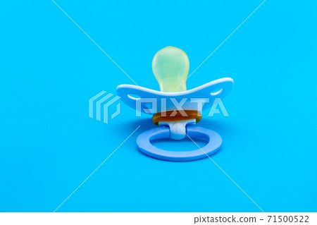 a blue pacifier made of soft silicone isolated on blue background back view with copy space. a blue pacifier made of soft silicone isolated on blue background back view with copy space. 71500522