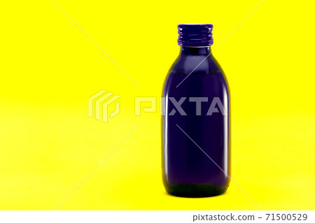 cough syrup medical blue glass bottle isolated on yellow background with copy space. cough syrup medical blue glass bottle isolated on yellow background with copy space. 71500529