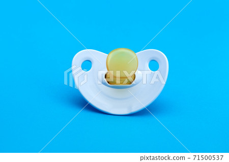 a blue baby pacifier made of soft silicone  isolated on blue background front view with copy space. 71500537
