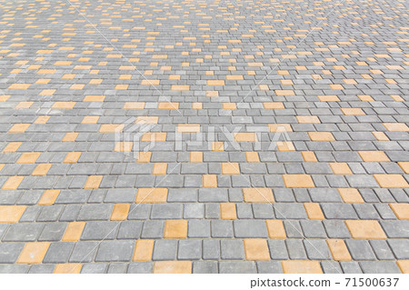 paving stone tiles pattern of square and rectangular shape of gray and yellow area are paved in perspective, closeup of the pedestrian walkway surface. 71500637