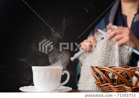 在熱氣騰騰的咖啡杯后面編織的女人 71503753