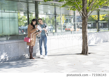 A Japanese woman asked for directions by a foreign woman during a meeting A Japanese woman asked for directions by a foreign woman during a meeting 71506143