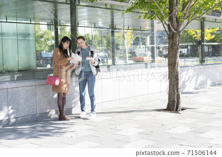 A Japanese woman asked for directions by a foreign woman during a meeting 71506144