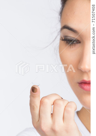 Young woman with contact lense 71507408