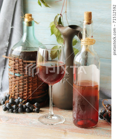Wine in glasses and bottles, grapes on a wooden table, home cooking, harvest season, autumn 71512592
