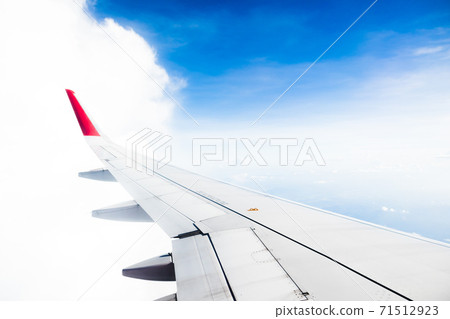 View from airplane on the aircraft white wing flying over blue sky and white clouds View from airplane on the aircraft white wing flying over blue sky and white clouds 71512923