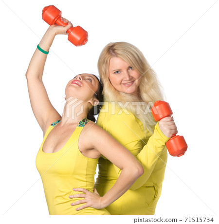 Woman team pumping up muscules with dumbbells on green background Woman team pumping up muscules with dumbbells on green background 71515734