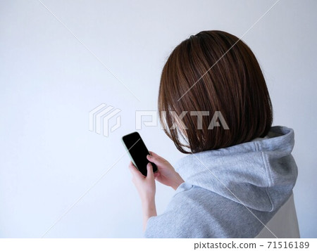 A woman touching a smartphone 71516189