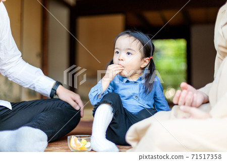 Toddler eating oranges on the porch of an old folk house Toddler eating oranges on the porch of an old folk house 71517358
