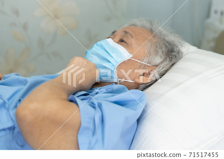 Asian senior or elderly old lady woman patient wearing a face mask in hospital  71517455