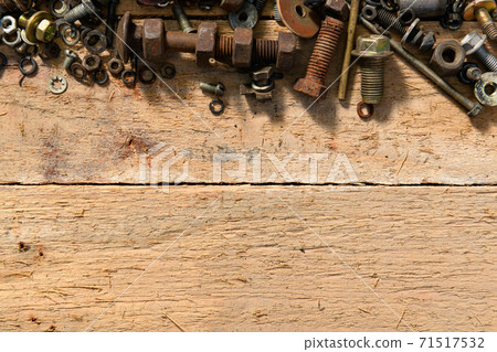 old vintage hand tools - set of screws and nuts on a wooden background with blank space for text old vintage hand tools - set of screws and nuts on a wooden background with blank space for text 71517532