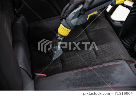 Man car wash worker cleaning and washing car interior 71519004